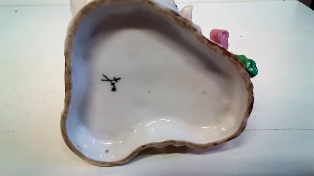 Coupe en porcelaine de Meissen polychromé représentant 3 puttis soutenant une coupe ornée d'un décor floral, Probablement XIXe siècle marque sous la base