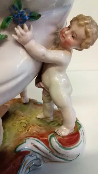 Coupe en porcelaine de Meissen polychromé représentant 3 puttis soutenant une coupe ornée d'un décor floral, Probablement XIXe siècle marque sous la base