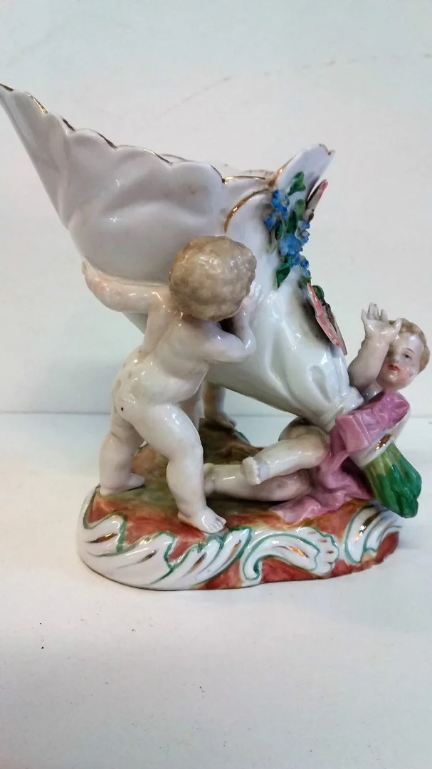 Coupe en porcelaine de Meissen polychromé représentant 3 puttis soutenant une coupe ornée d'un décor floral, Probablement XIXe siècle marque sous la base