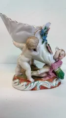Coupe en porcelaine de Meissen polychromé représentant 3 puttis soutenant une coupe ornée d'un décor floral, Probablement XIXe siècle marque sous la base