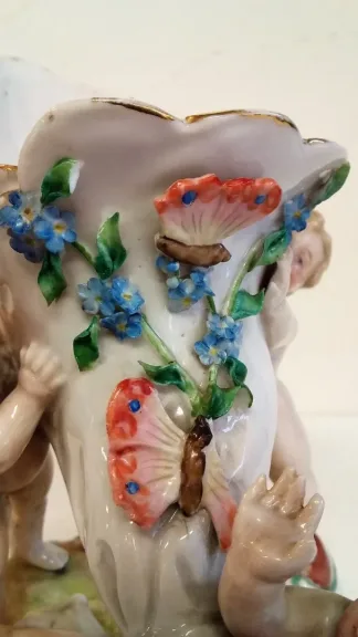 Coupe en porcelaine de Meissen polychromé représentant 3 puttis soutenant une coupe ornée d'un décor floral, Probablement XIXe siècle marque sous la base