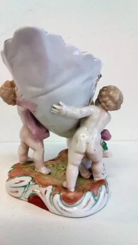 Coupe en porcelaine de Meissen polychromé représentant 3 puttis soutenant une coupe ornée d'un décor floral, Probablement XIXe siècle marque sous la base