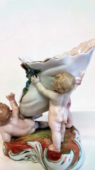 Coupe en porcelaine de Meissen polychromé représentant 3 puttis soutenant une coupe ornée d'un décor floral, Probablement XIXe siècle marque sous la base