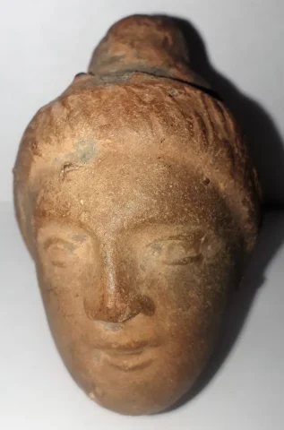 Tête antique  de femme à la coiffure méchée relevée en un haut chignon terre cuite