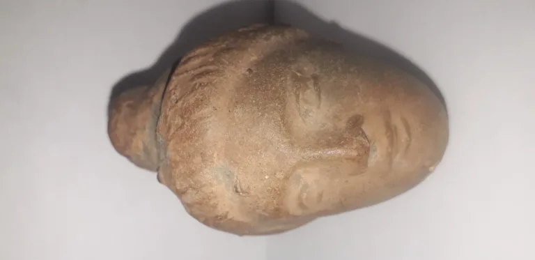 Tête antique  de femme à la coiffure méchée relevée en un haut chignon terre cuite