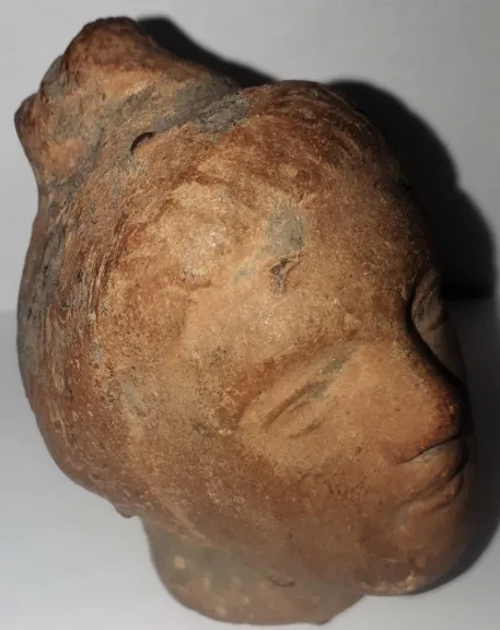 Tête antique  de femme à la coiffure méchée relevée en un haut chignon terre cuite