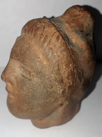 Tête antique  de femme à la coiffure méchée relevée en un haut chignon terre cuite