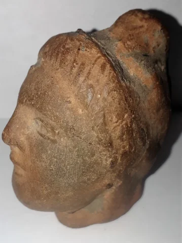 Tête antique  de femme à la coiffure méchée relevée en un haut chignon terre cuite