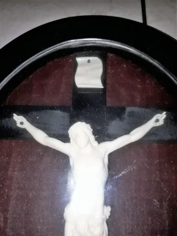 Christ en ivoire sculpté sur sa croix ou crucifix dans un cadre en bois noirci, d'époque XIXème siècle