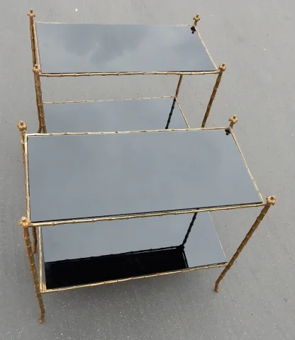 Paire de tables en bronze doré, plateaux en verre laqué noir, décor palmier avec cimes en haut des montants  Tout est vissé Bon état Circa 1950/70  Longueur : 74 cm Largeur : 38 cm Hauteur : 68 cm