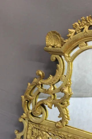 Miroir Régence à Parecloses en bois sculpté et doré XVIIIe