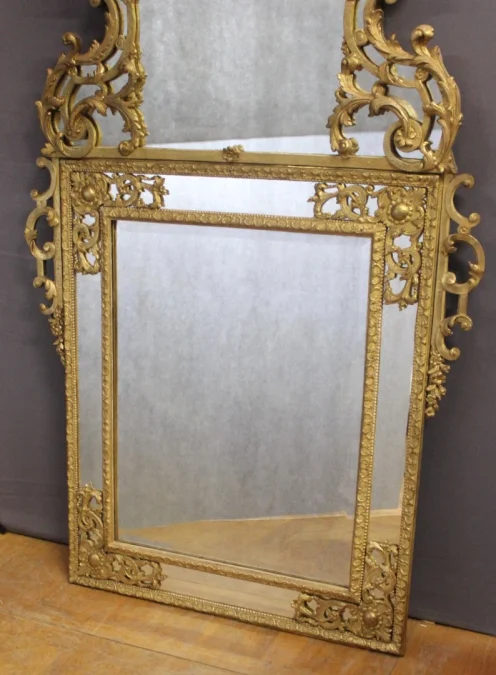 Miroir Régence à Parecloses en bois sculpté et doré XVIIIe