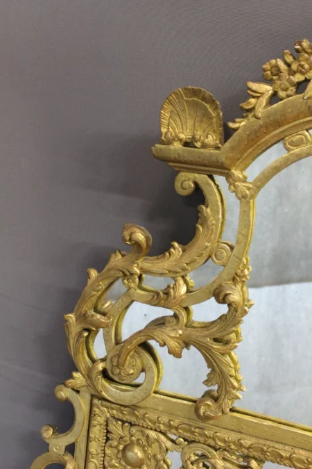 Miroir Régence à Parecloses en bois sculpté et doré XVIIIe