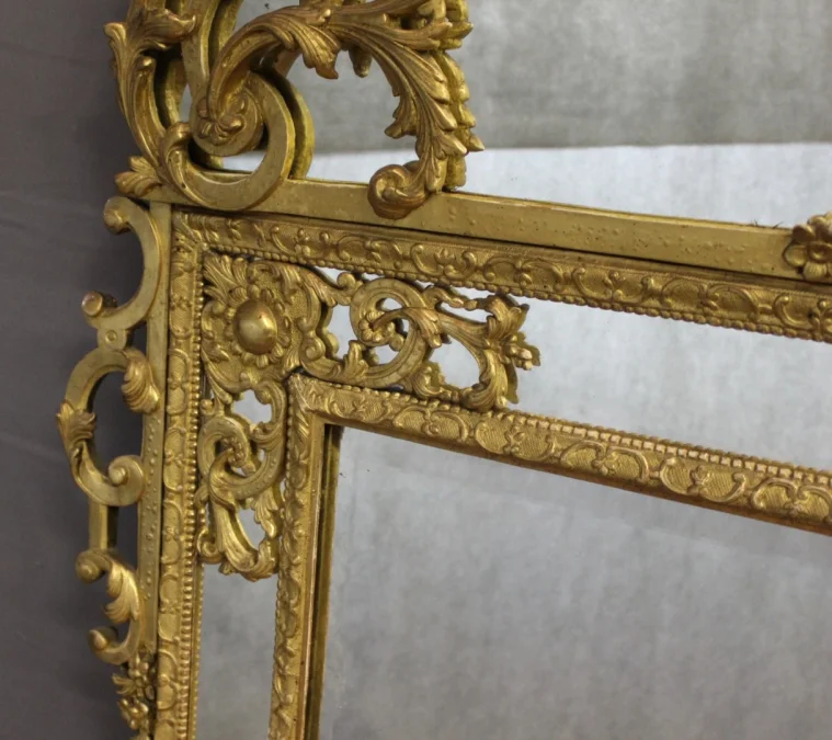 Miroir Régence à Parecloses en bois sculpté et doré XVIIIe