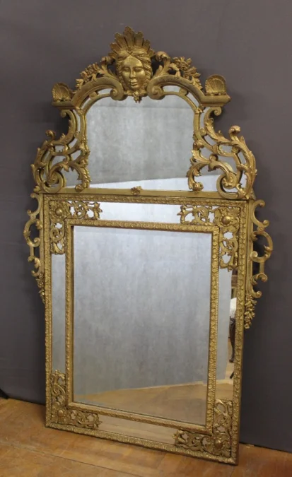 Miroir Régence à Parecloses en bois sculpté et doré XVIIIe