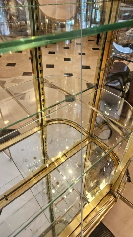 SIEGEL : Rare vitrine murale d’exposition en laiton et bronze à cotés bombés. Début du XX° siècle. — Excellent état