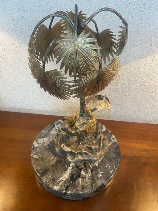 Sculpture en métal figurant un chamelier dans une oasis