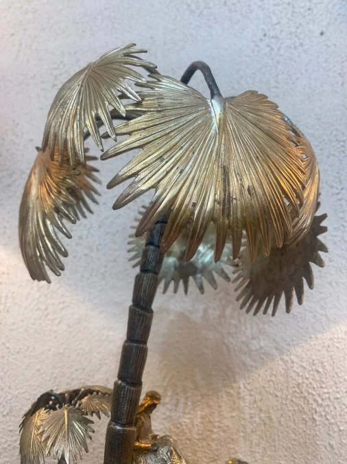 Sculpture en métal figurant un chamelier dans une oasis
