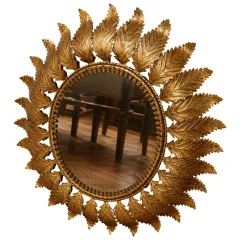 Sunburst mirror in gilt metal with leaf decoration